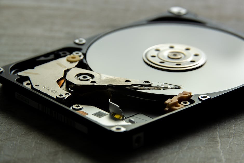 Detailed view of an open hard drive, showcasing the disk platter and actuator arm.